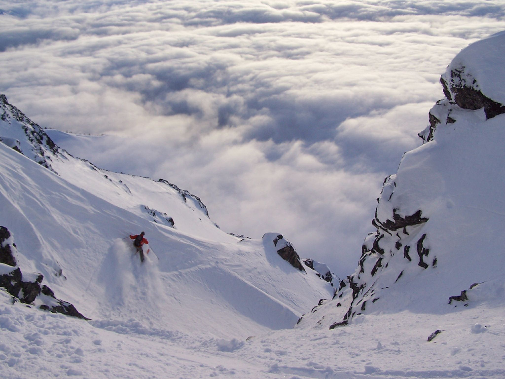 Wintersport extrem: Ski-Fahrer beim Extremsport. Abfahrt mit Wolken im Hintergrund